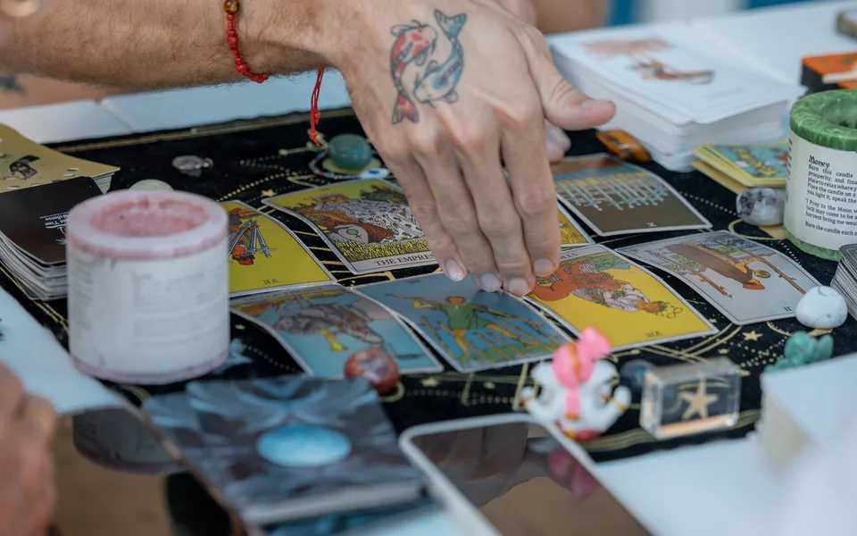An overhead tarot spread surrounded by crystals, candles and ritual objects