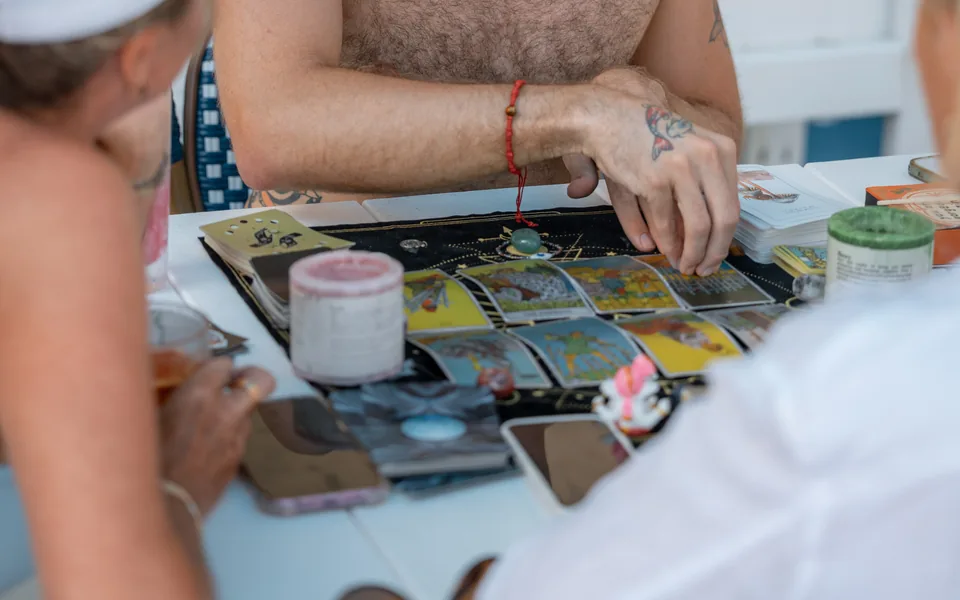 Alex reading tarot for two guests seated at an outdoor table